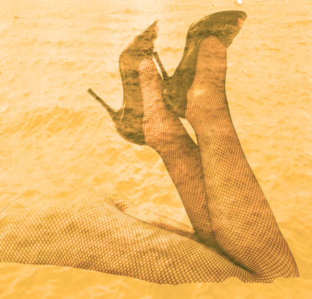 Double exposure female legs and high heels with ocean water backgroundの写真素材