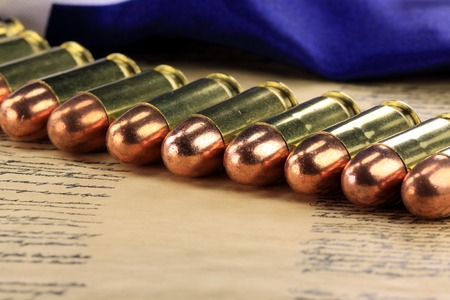 Row of 45 caliber ammunition with US flag in backgroundの写真素材