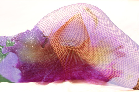 Double exposure female legs in fishnet stockings with flower backgroundの写真素材