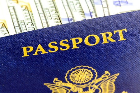 United States passport with one hundred dollar bills