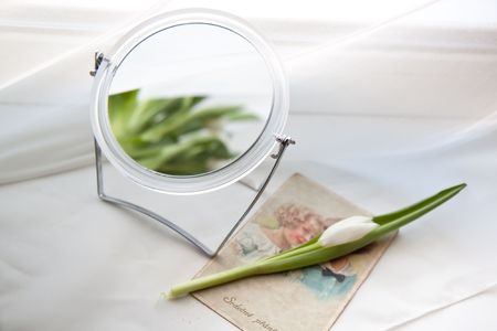 White tulip with mirror near windowの写真素材