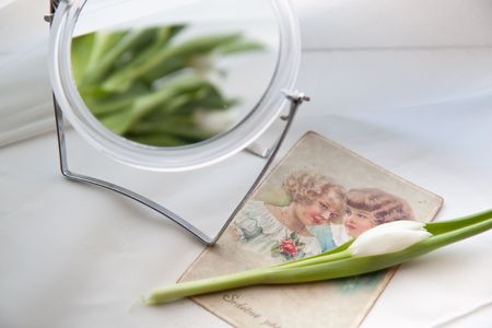 White tulip with mirror near windowの写真素材