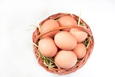 eggs in a basket in a white backgroundの写真素材