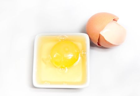 yolk and a shell on a white backgroundの写真素材
