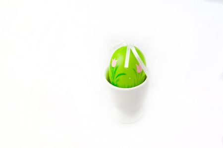 Painted green Easter Egg in a egg-cupの写真素材