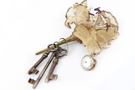 Three old keys with old watch and decor flowerの写真素材