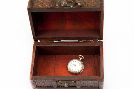 old watch on a wooden chest on a white backgroundの写真素材
