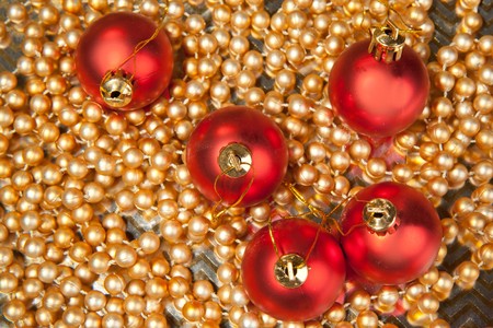 Red christmas balls on the golden beadsの写真素材