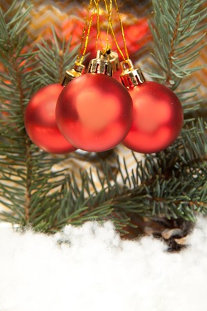 Three red christmas balls with christmas tree on the gold backgroundの写真素材