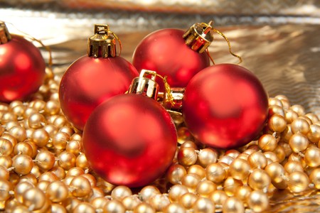 Red christmas balls on the golden beadsの写真素材