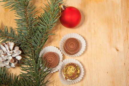 Red christmas ball with a homemade chocolate on a wooden table