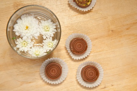 Homemade sweet chocolate and white flowers on the wooden tableの写真素材