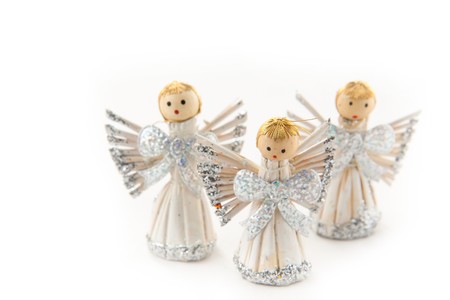 Three shining christmas angel figurines on white background の写真素材