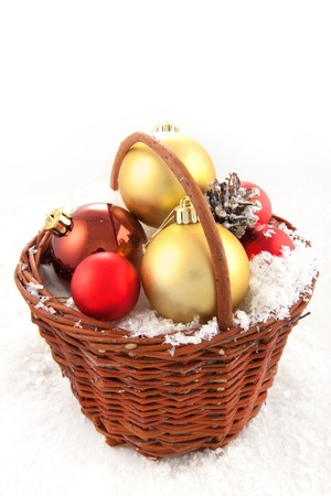 Colorful christmas toys in the basket on the snowの写真素材