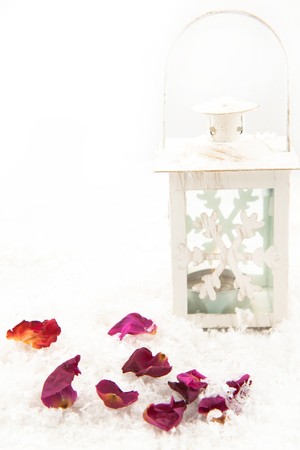White christmas lightning latern and rose's petals on a snowの写真素材