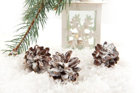 White christmas lightning lantern and forest cones on a snowの写真素材
