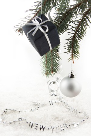 Silver christmas balls and gift on a christmas treeの写真素材