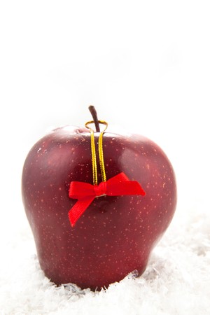 Fresh red apple with christmas bow on the white snowの写真素材