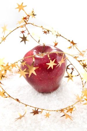 Fresh red apple with christmas stars on the white snowの写真素材