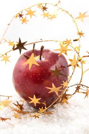 Fresh red apple with christmas stars on the white snowの写真素材