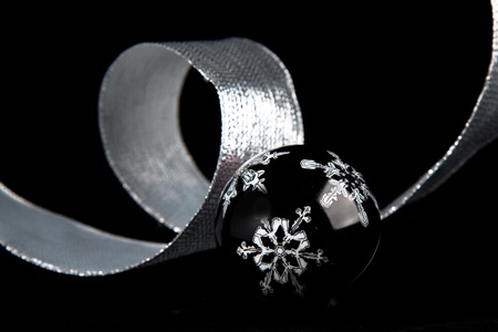 Black christmas ball with the white snowflake on the black backgroundの写真素材