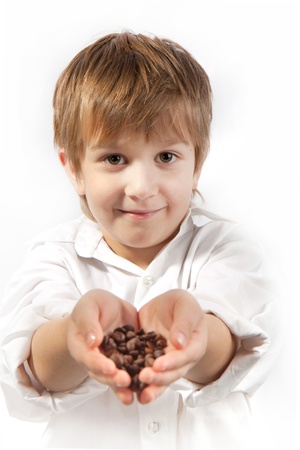 Little boy with coffee beans in the hands on the white backgroundの写真素材