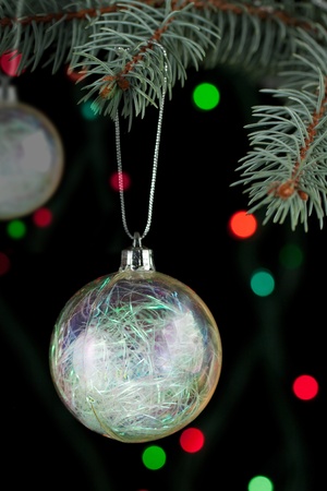 Transparent christmas ball with a christmas tree on the black backgroundの写真素材