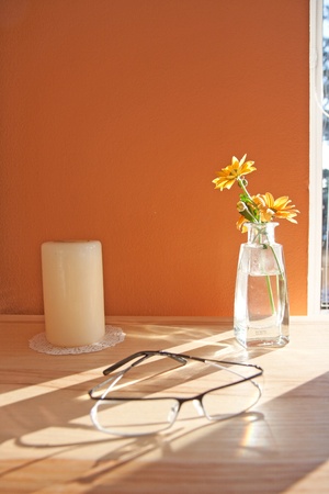 Modern glasses and flowers in interior near the windowの写真素材
