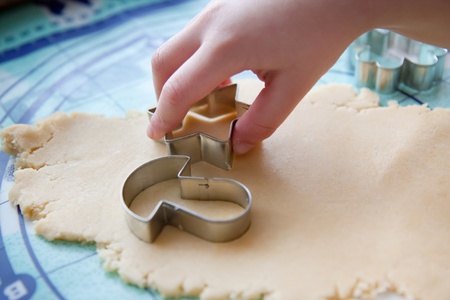 The young boy on a kitchen cut the cookies from the doughの写真素材