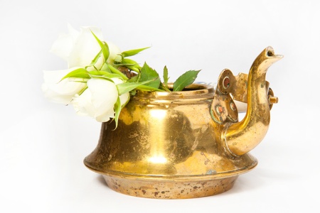 Old teapot with white roses on the white backgroundの写真素材