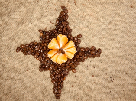 Fragrant fried coffee beans as a star with tangerineの写真素材