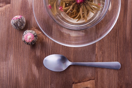 Transparent cup of green tea with the teaspoon on the wooden tableの写真素材