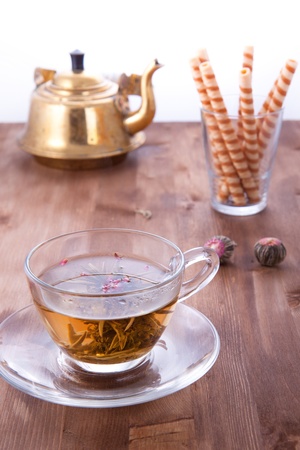 Transparent cup of green tea with old teapot and wafersの写真素材
