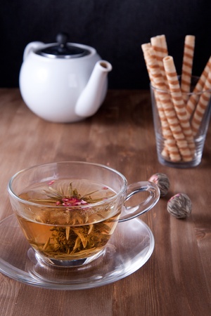 Transparent cup of green tea with white teapot and wafersの写真素材