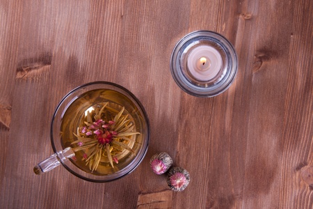 Transparent cup of green tea and burning candleの写真素材