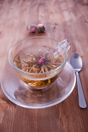 Transparent cup of a green tea with the teaspoon on the wooden tableの写真素材
