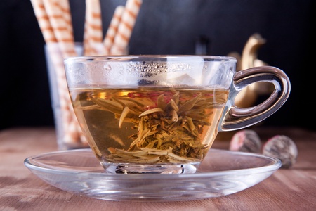 Transparent cup of a green tea with the sweet wafersの写真素材