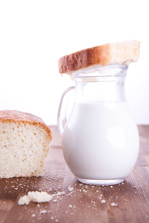 Fresh cooking bread with jug of milkの写真素材