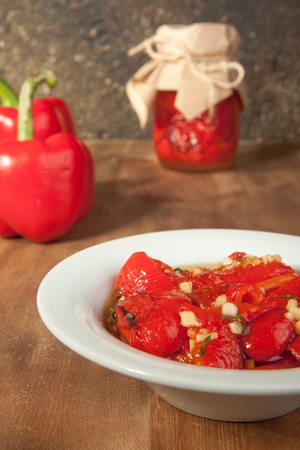 Snack from red paprika in olive oil and fresh red paprikaの写真素材