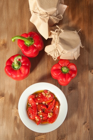 Red paprika in olive oil, fresh red paprika and tow potの写真素材