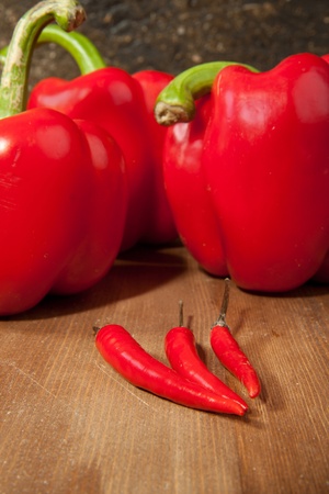 Red chili pepper and peppers and red paprika on the wooden tableの写真素材