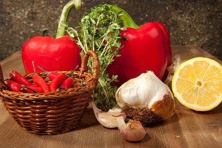Red paprika, sliced lemon, garlic and fresh herb on the wooden tableの写真素材
