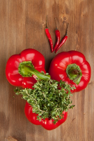 Red paprika and chili peppers with fresh herb on the wooden tableの写真素材