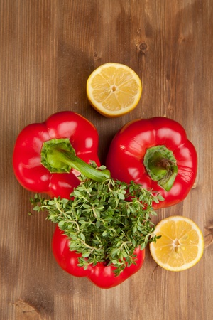 Red paprika, sliced lemon and fresh herb on the wooden tableの写真素材