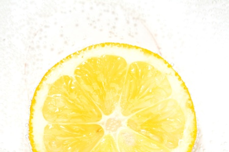 Single cross section of lemon with the bulbs in the waterの写真素材