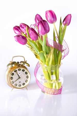 bouquet of violet tulips near the old golden clockの写真素材
