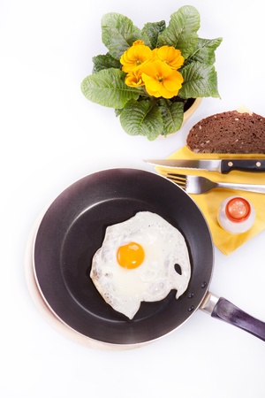 Breakfast with the fried egg and loaf of bread over white backgroundの写真素材