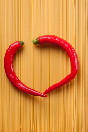 Tow red hot chili peppers as a heart on the spaghettiの写真素材