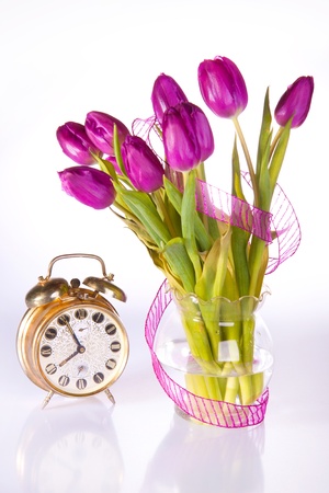 bouquet of violet tulips near the old golden clockの写真素材