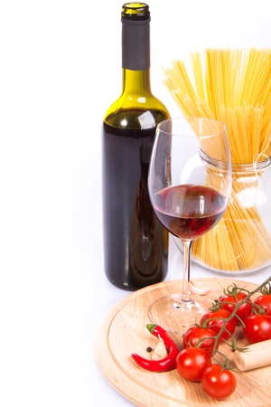 Glass of red wine near italian spaghetti and vegetables for pastaの写真素材